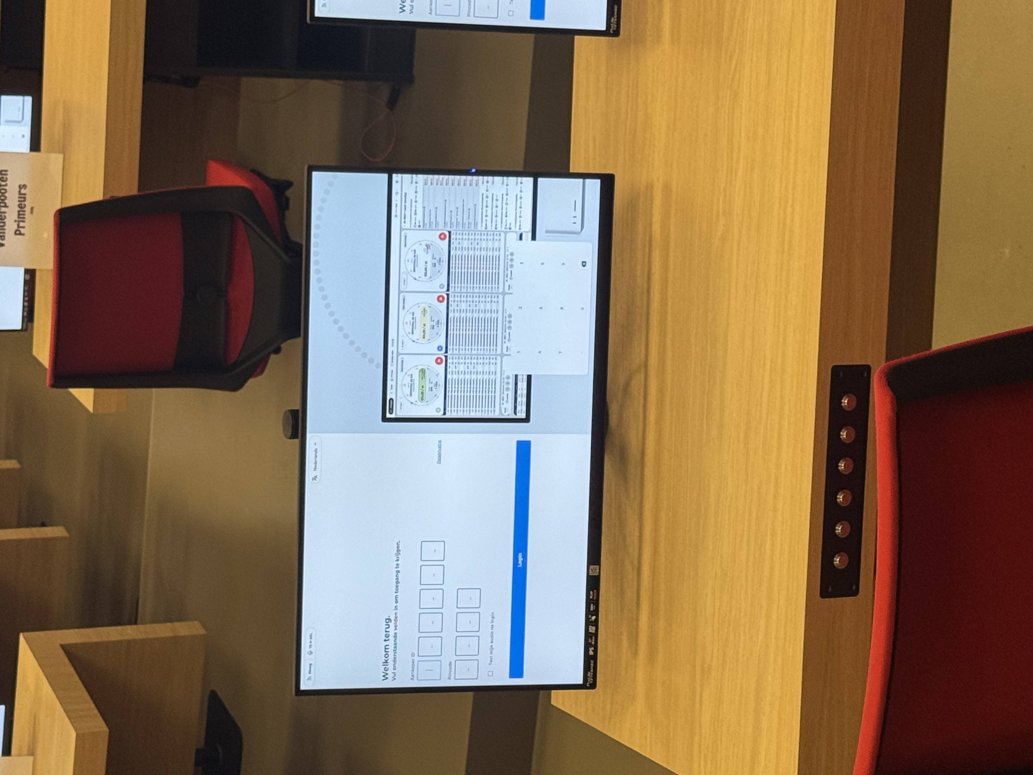 Auction hall with large display showing live auction clocks and rows of bench computers